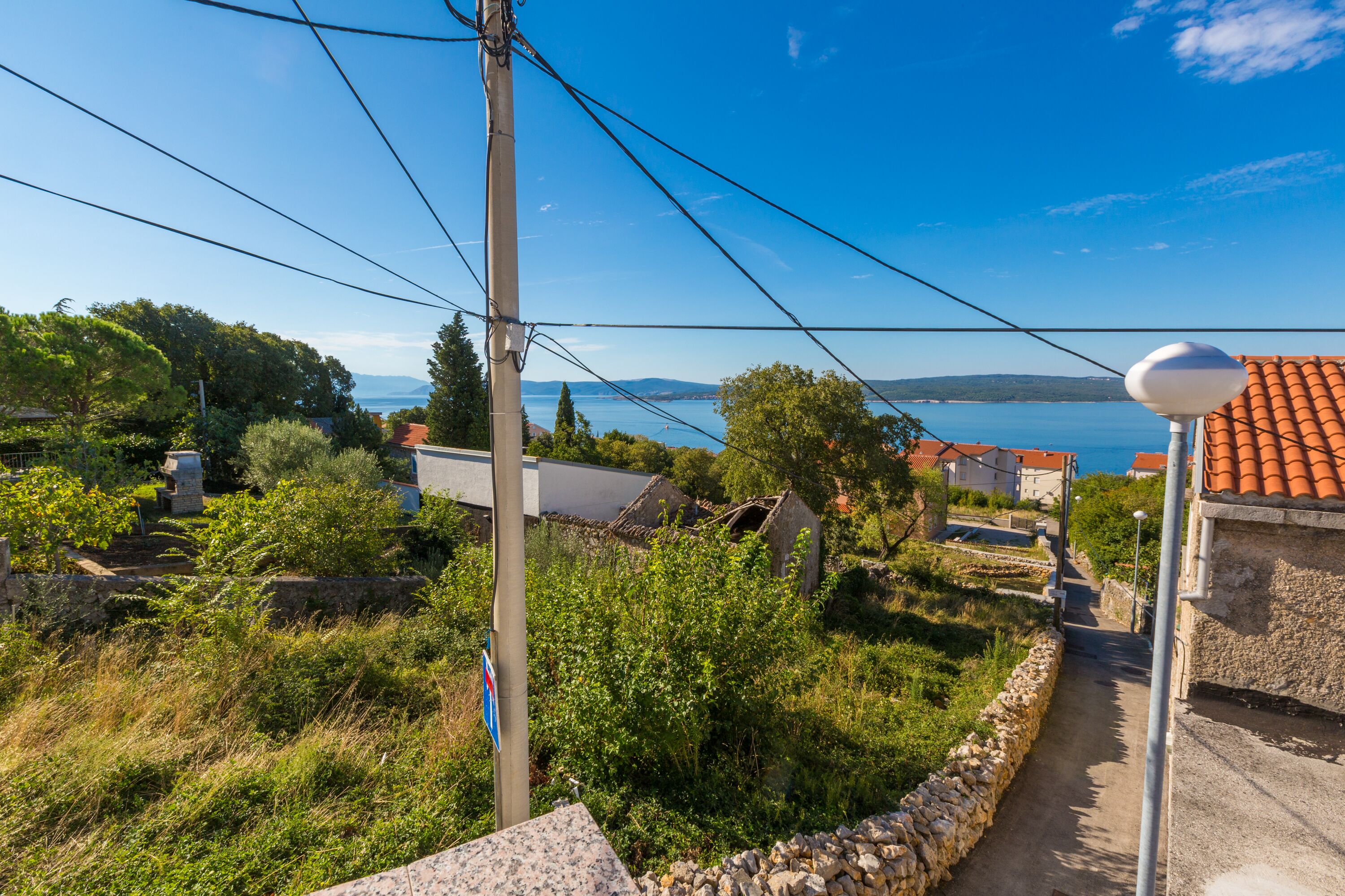 A coastal village with stone houses, a narrow path, and a view of the sea.