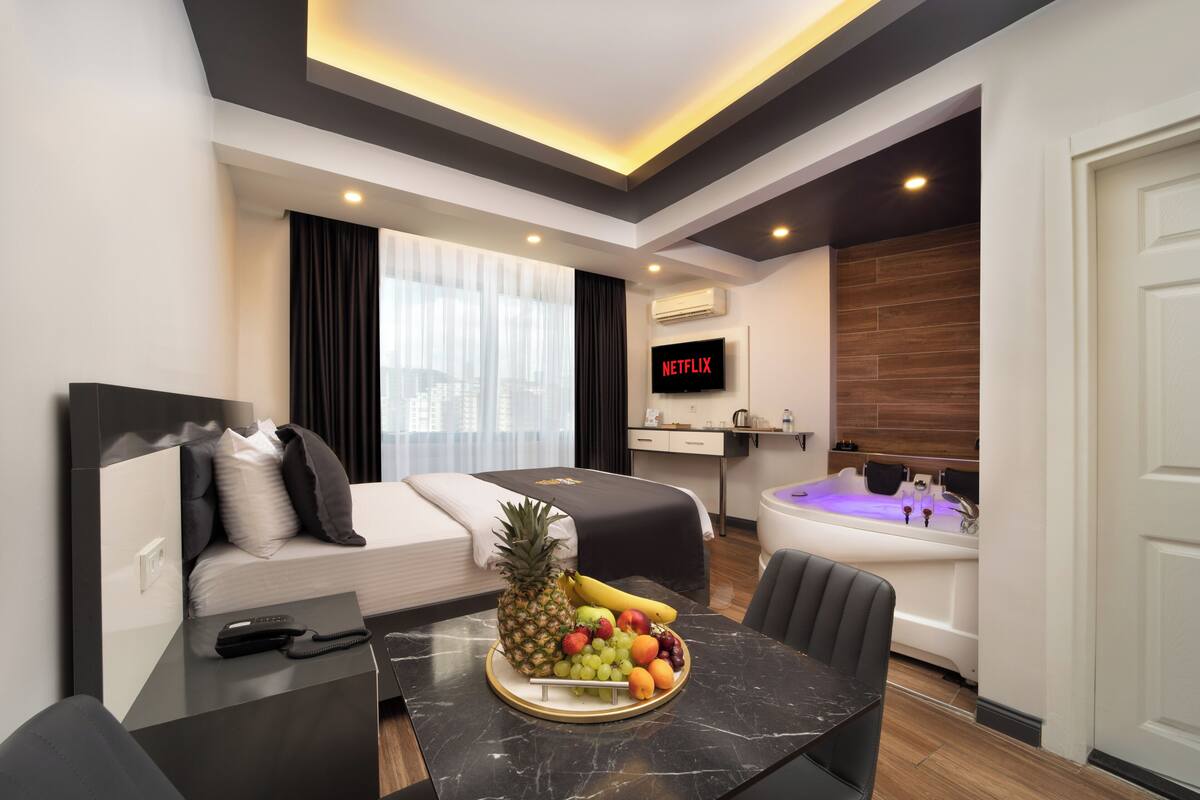 Suite Deluxe, 1 grand lit, baignoire à jets | Coffre-fort, rideaux d’obscurcissement, système d’insonorisation
