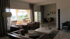 A modern living room with a sofa, coffee table, and dining area. - Ref. Nav44 -  (Rosas / Roses)