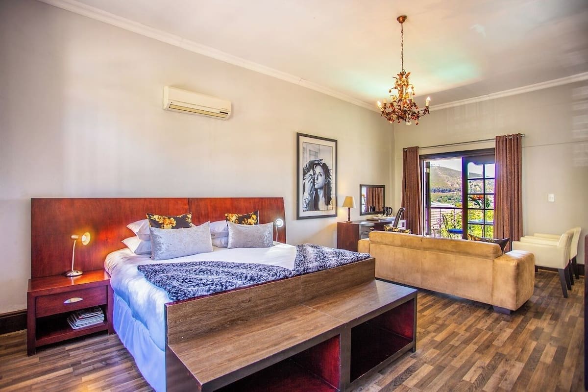Une chambre d’hôtel moderne, dotée d’un grand lit, d’un canapé, d’un bureau et offrant une vue sur l’extérieur.