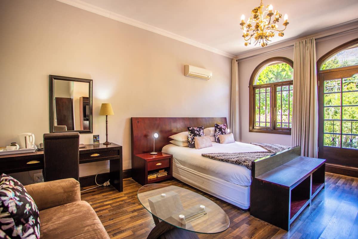Une chambre d’hôtel équipée d’un lit, d’un bureau, d’une chaise et d’une table basse en verre.