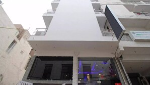 Un immeuble à plusieurs étages doté d’une structure verticale centrale, de balcons et d’une enseigne indiquant qu’il s’agit d’un hôtel.