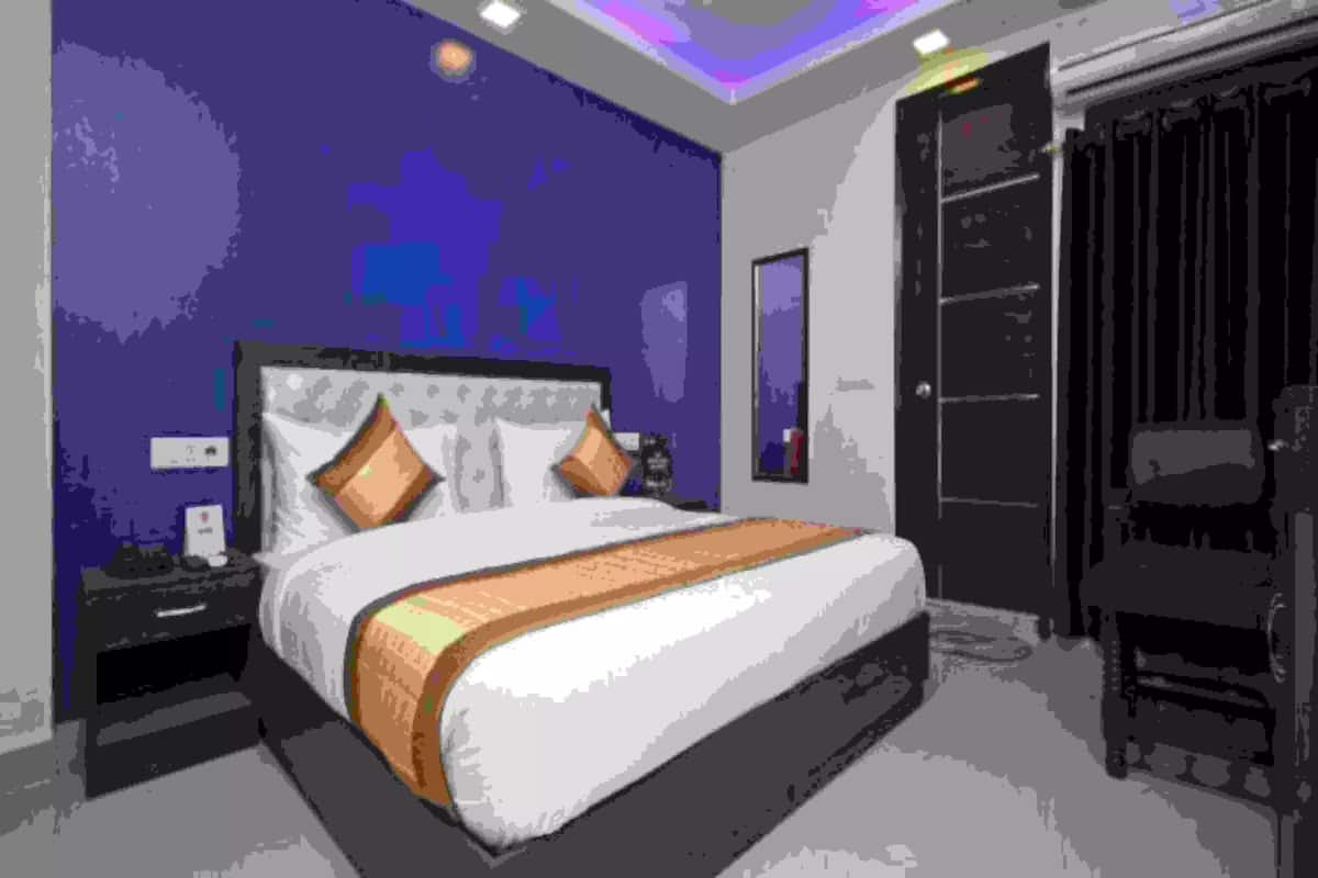 A modern bedroom with a large bed, a nightstand, a dresser, and a wardrobe.