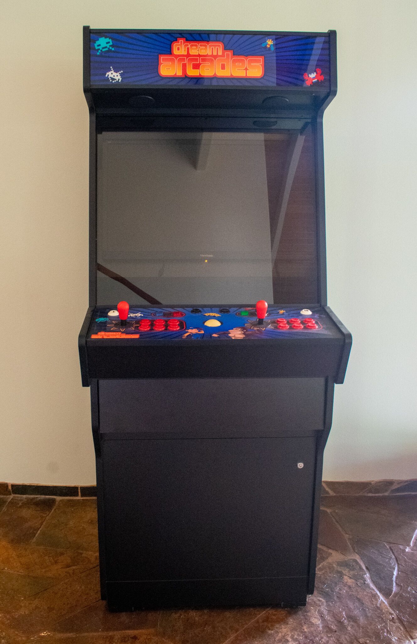 A retro arcade machine with a screen displaying a game, a joystick, and multiple buttons.