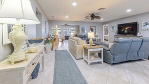 A modern living room with a sofa, TV, and decorative items. - Manatee Oasis 4bed/3bath single family home with private pool & dockage located on the gulf side of Marathon (Marathon)