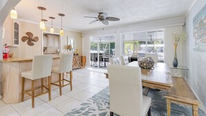 A modern kitchen with a bar area, dining space, and a ceiling fan. - Manatee Oasis 4bed/3bath single family home with private pool & dockage located on the gulf side of Marathon (Marathon)