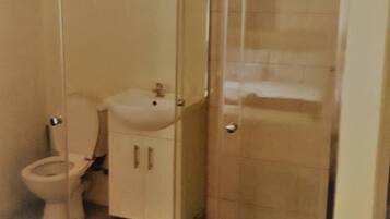 Een douche, handdoeken, zeep, toiletpapier