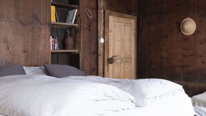 Une pièce en bois avec un lit, une bibliothèque et une porte.