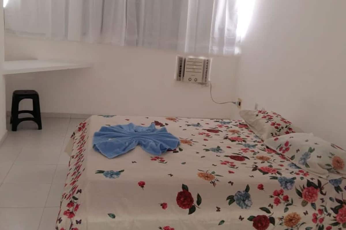 Ein Schlafzimmer mit Bett, Schreibtisch und Stuhl.