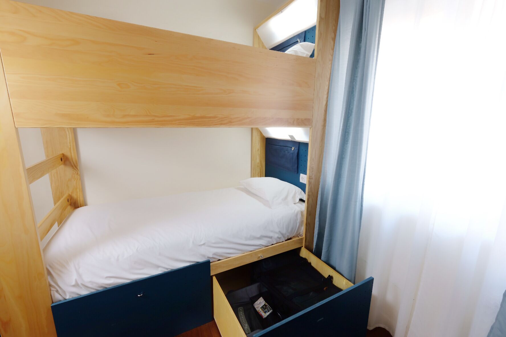 Un lit superposé avec un lit inférieur et un tiroir en dessous.