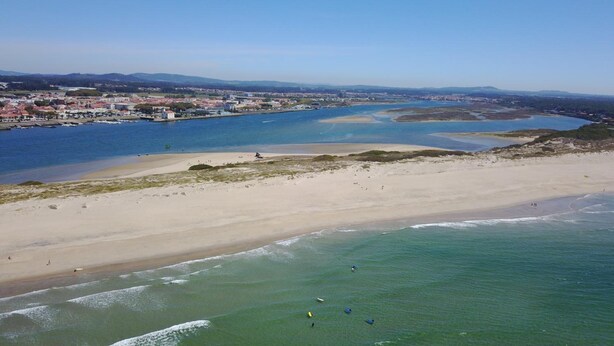A coastal beach with clear waters, a sandy shore, and a town in the background. - InnEsposende Sports Hostel (Esposende)