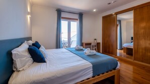 A bedroom with a bed, a desk, and a large mirror. - InnEsposende Sports Hostel (Esposende)