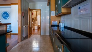 A modern kitchen with stainless steel appliances, wooden cabinets, and a visible sign indicating kitchen rules. - InnEsposende Sports Hostel (Esposende)