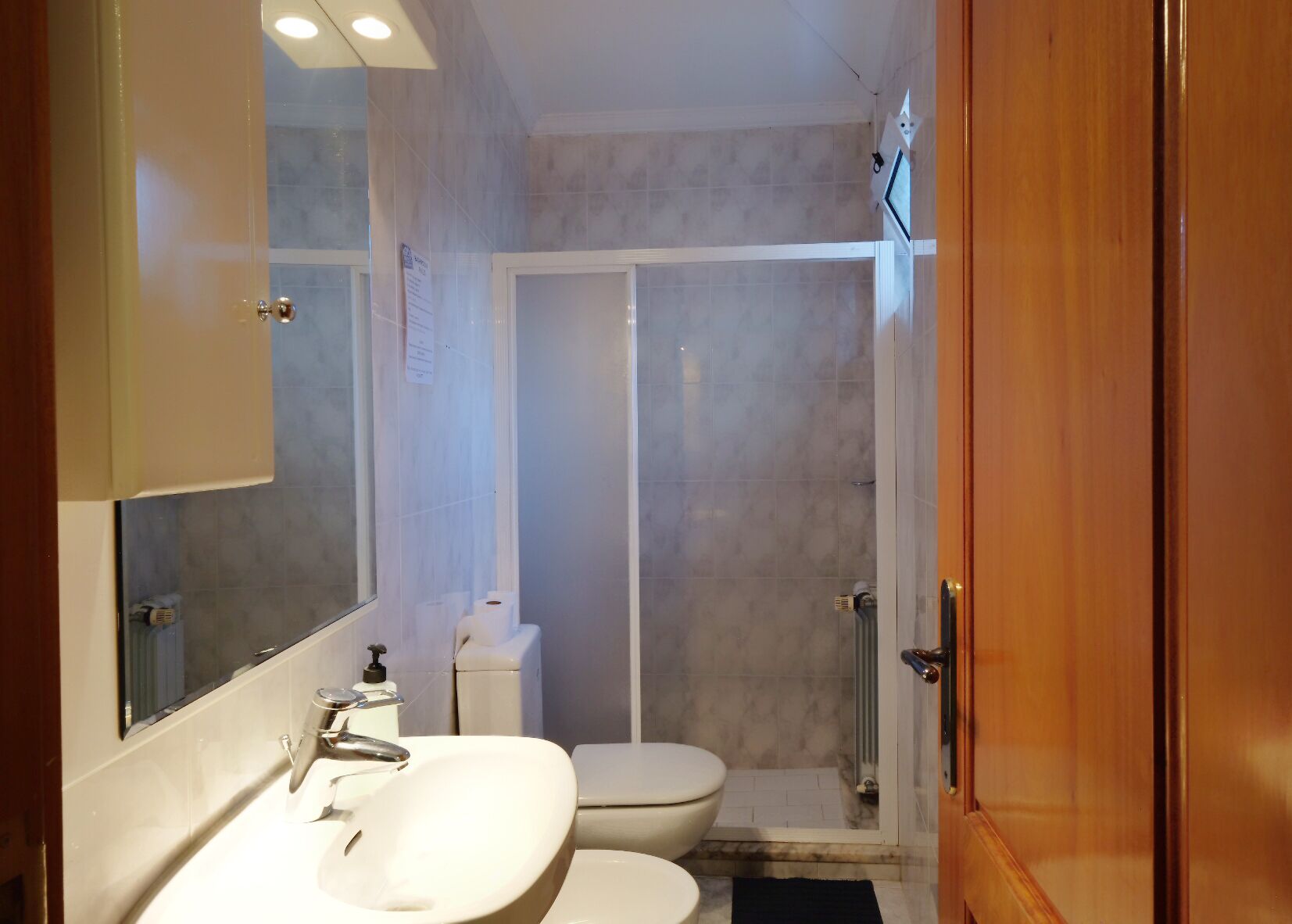 A bathroom with a sink, toilet, and shower.