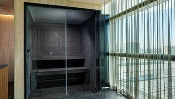 A modern room with a glass partition, a view of the city, and a built-in bench.