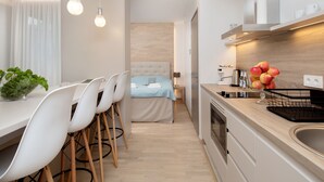 Une cuisine moderne avec un coin repas, un lit et un petit espace de vie.