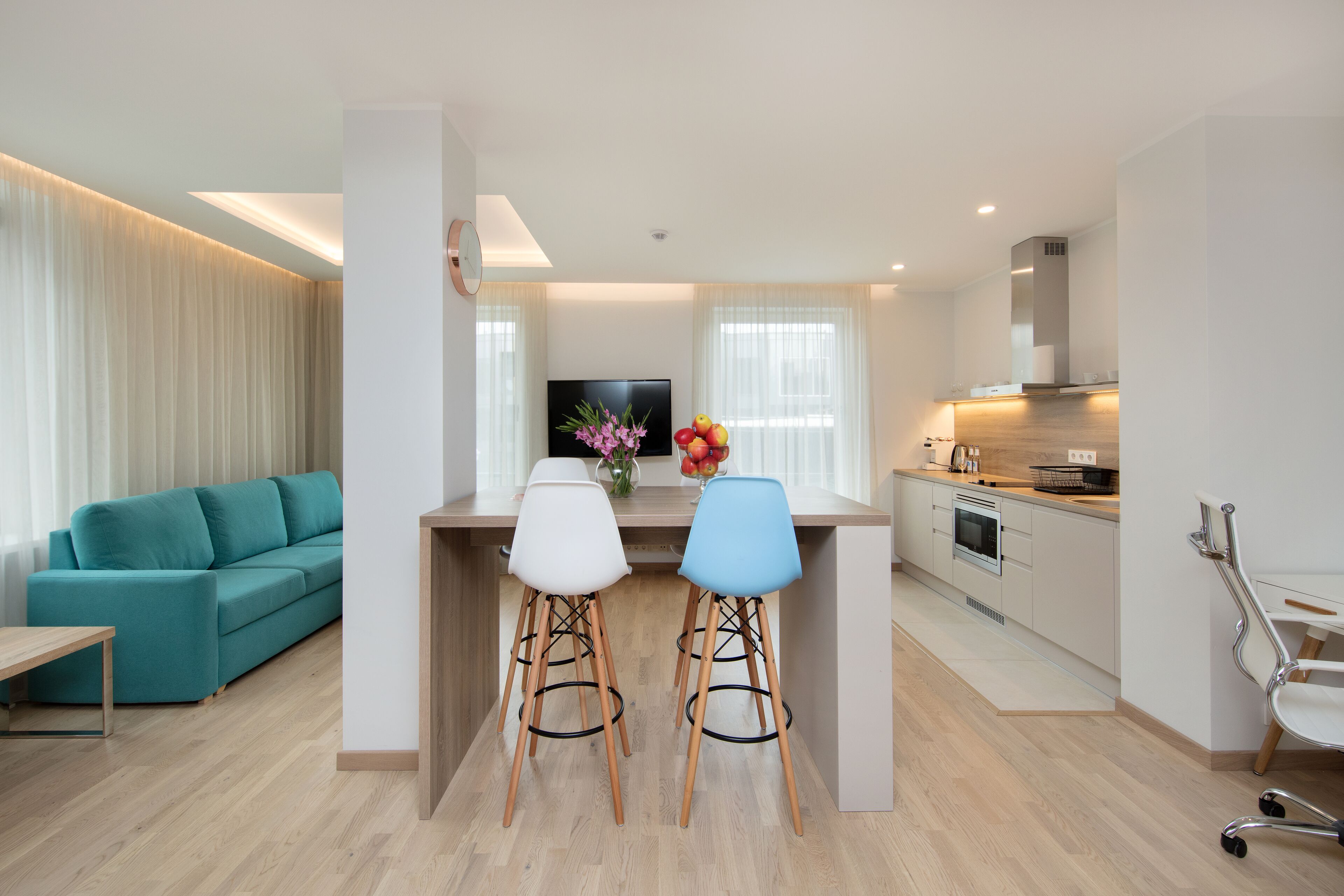 A modern apartment with a living room, a kitchen, and a dining area.