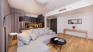 A modern living room with a grey sectional sofa, a black coffee table, and a wooden bench.