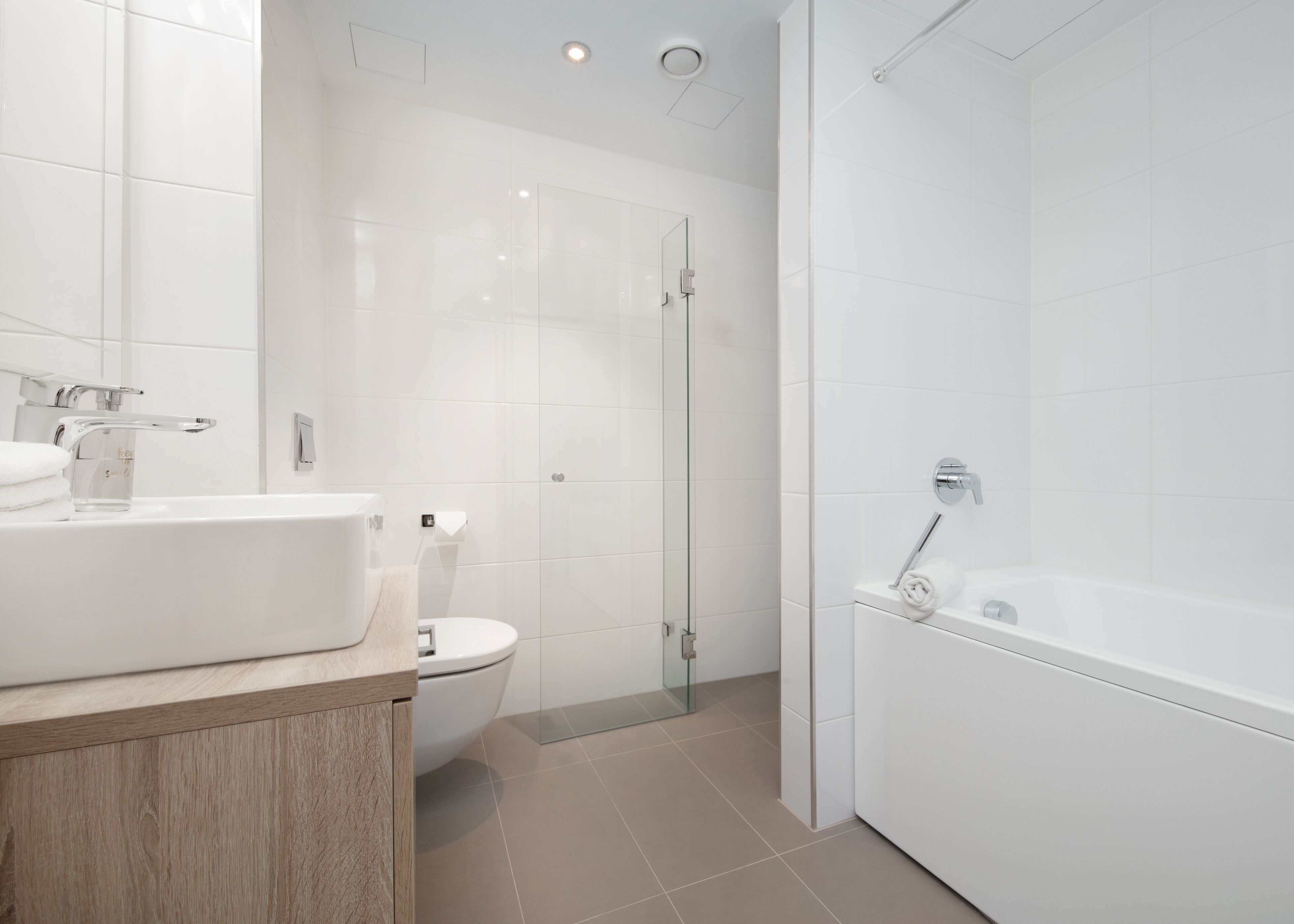 A modern bathroom with a toilet, sink, and shower area.