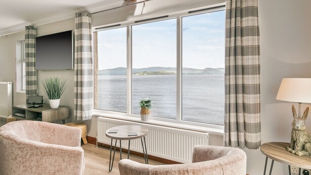 A living room with a large window, a sofa, a small table, and a decorative rabbit statue. - Creinch Lodge-Sleeps 2 - sleeps 2 guests  in 1 bedroom (Alexandria)
