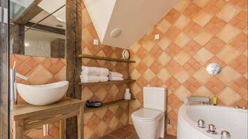 A bathroom with a white sink, a toilet, a bathtub, and a shelf with towels.