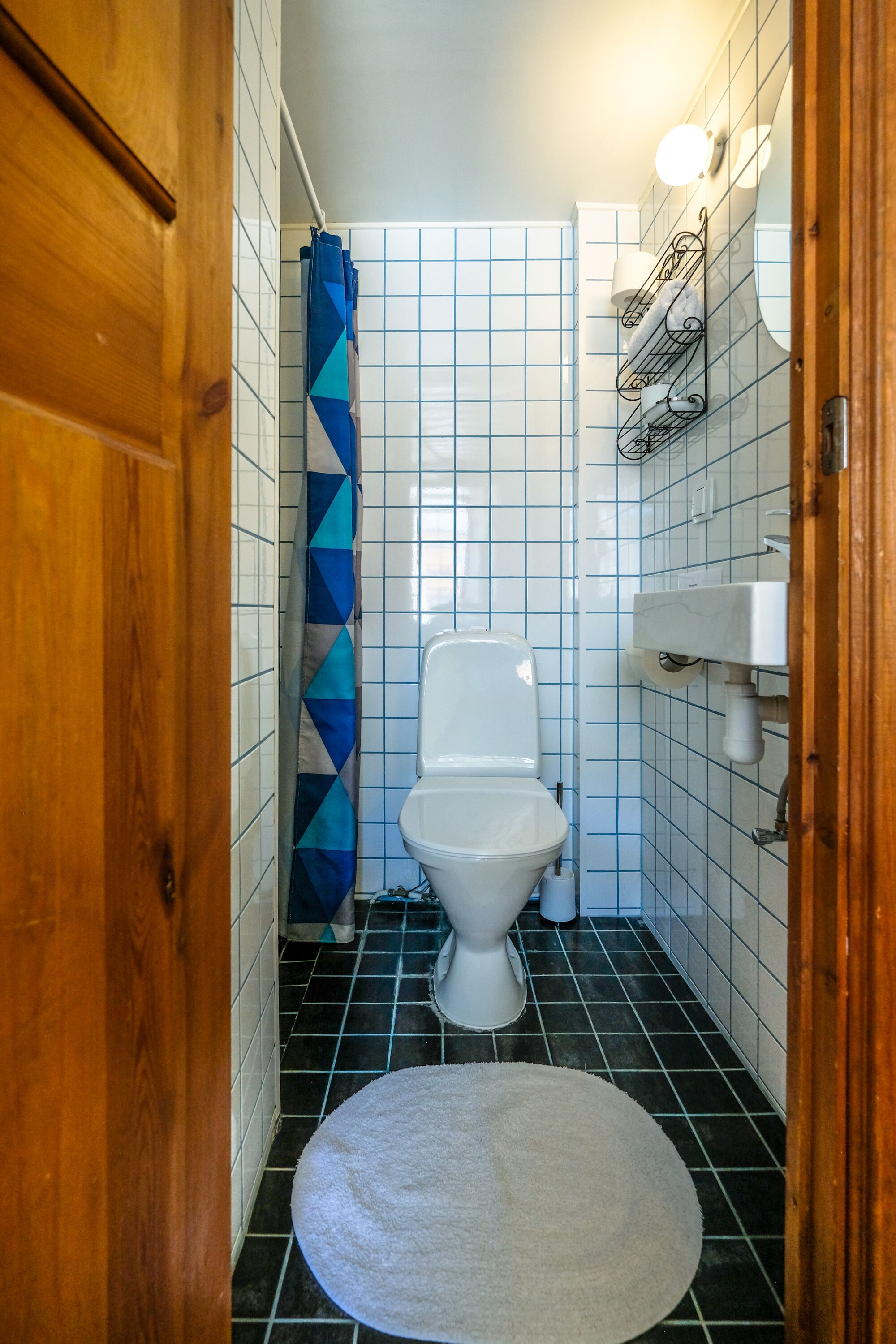 A small bathroom with a toilet, a sink, and a shower curtain.