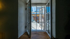 A narrow stairway leading to an open window with a view of buildings outside. - Blacksmith Old Town Apartments (Tallinn)