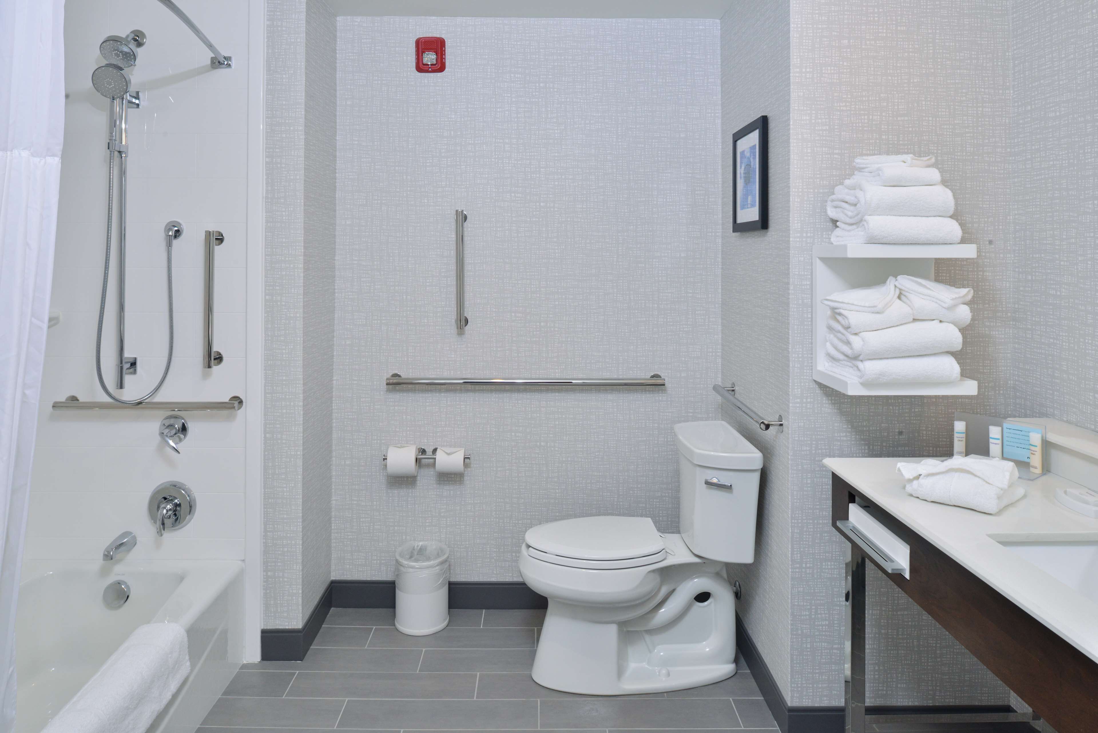A modern bathroom with a bathtub, toilet, and shower.
