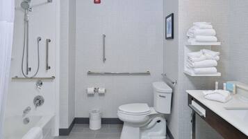 A modern bathroom with a bathtub, toilet, and shower.
