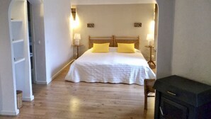 A bedroom with a large bed, two bedside lamps, and a wooden headboard. - Sa Plana Petit Hotel (Estellencs)