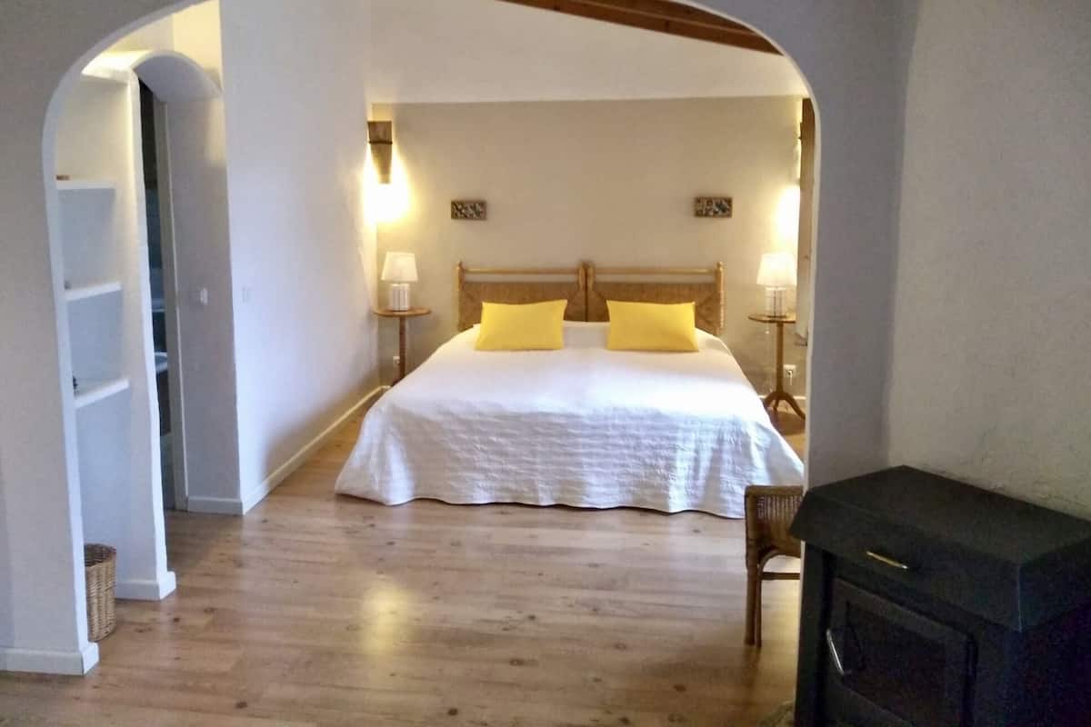 Un dormitorio con una cama grande, dos lámparas de noche y un cabecero de madera.