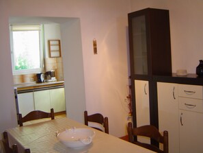 Un comedor con una mesa, sillas y un armario.