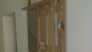 A room with a wooden vanity, a mirror, and a small cabinet with drawers. - Apartments Iva (Crikvenica)