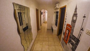A narrow hallway with a tiled floor, a mirror on the left, and a poster of Big Ben on the right. - Apartment Milly (Vinodol)