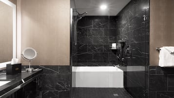 A modern bathroom with a glass-enclosed shower, a standalone bathtub, and a vanity with a mirror.