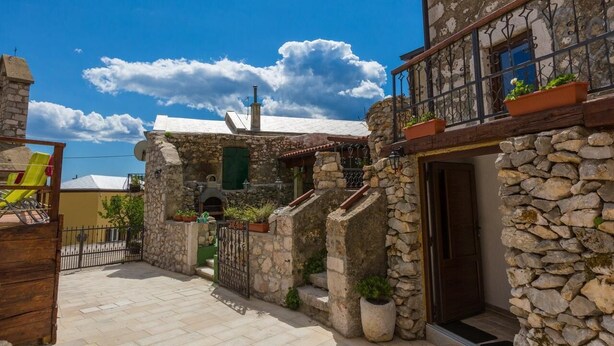 A stone building with a balcony, a stone gate, and potted plants. - Villa Holiday Coral (Vinodol)