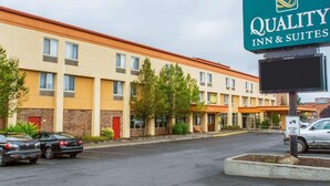 Un hotel con il cartello 'Quality Inn & Suites' e un parcheggio pieno di auto.