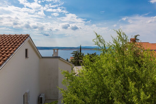 A building with a tiled roof and a view of a body of water in the background.