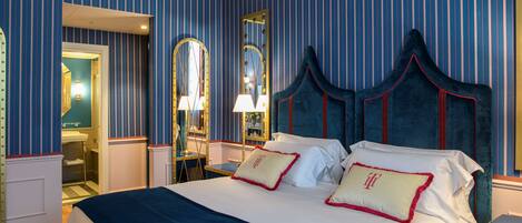 A hotel room with a large bed, a mirror, and a vanity with a lamp.