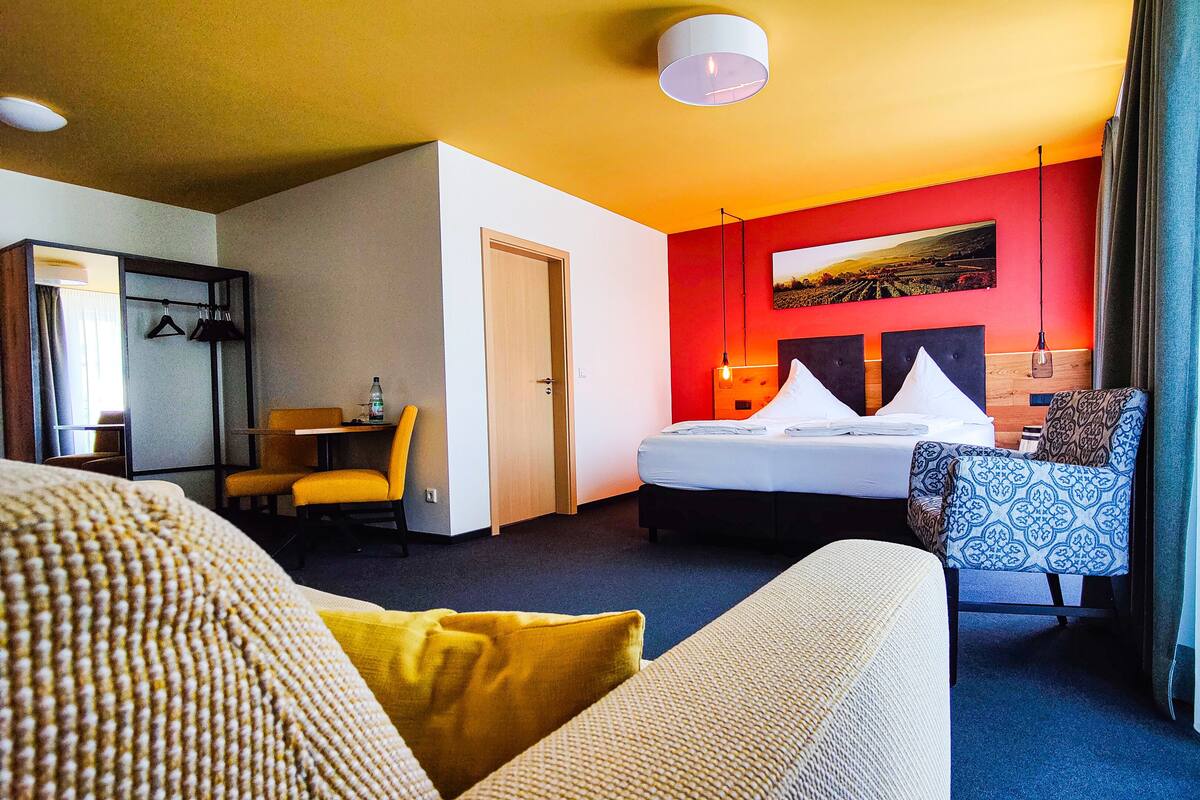 Una habitación de hotel con cama, escritorio, silla y sofá.