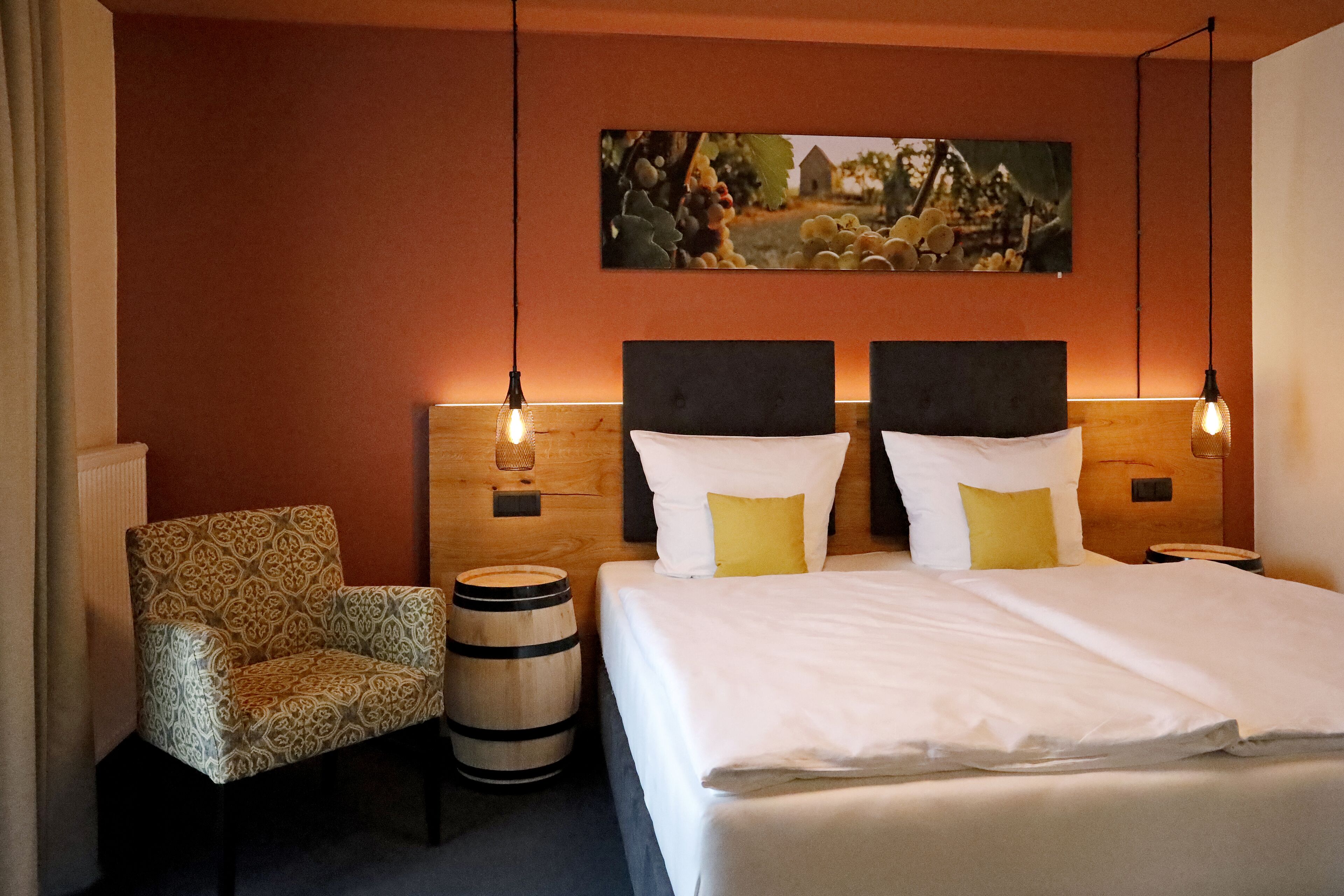 Ein Hotelzimmer mit einem Bett, zwei Nachttischen, einem Sessel und einem Holzbottich.