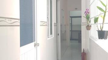A corridor with doors, a fire extinguisher, and potted plants.