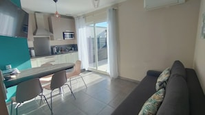 Eine moderne Wohnung mit Küche, Essbereich und Wohnzimmer mit Sofa.