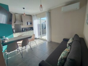 Un appartement moderne comprenant une cuisine, un coin repas et un salon avec un canapé.