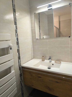 Ein Badezimmer mit Waschbecken, Spiegel und Handtuchhalter.