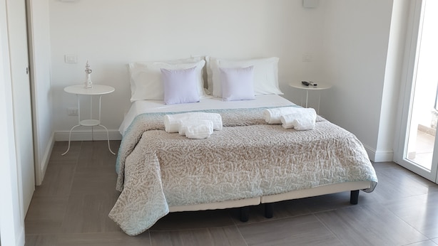 Ein ordentlich eingerichtetes Schlafzimmer mit einem Bett, Nachttischen und einem kleinen runden Tisch.