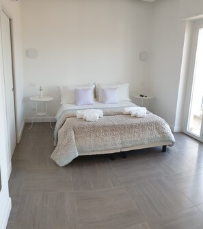 Ein ordentlich eingerichtetes Schlafzimmer mit einem Bett, Nachttischen und einem kleinen runden Tisch.
