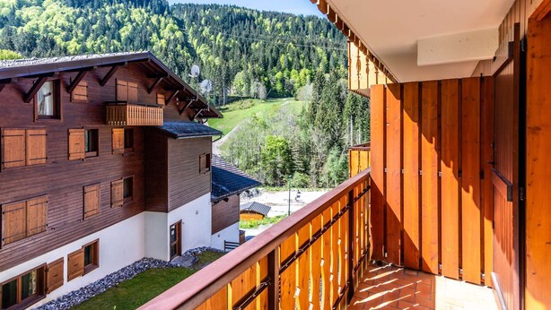A wooden building with a balcony overlooking a mountainous landscape. - Lovely apartment at the bottom of the slopes (MORZINE)
