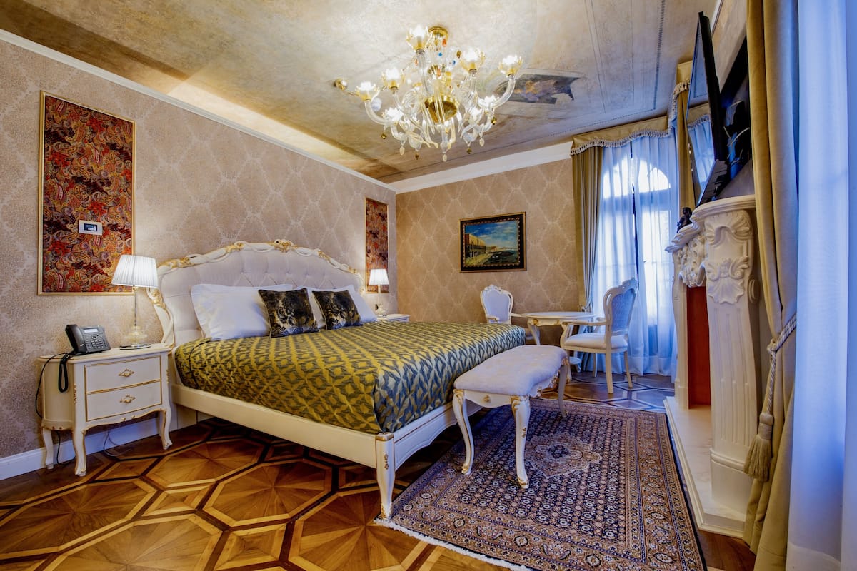 A bedroom with a bed, bedside tables, a desk, and a chair.