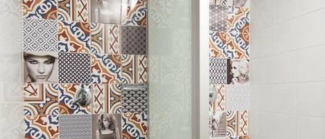 A bathroom with patterned tiles and a shower area.